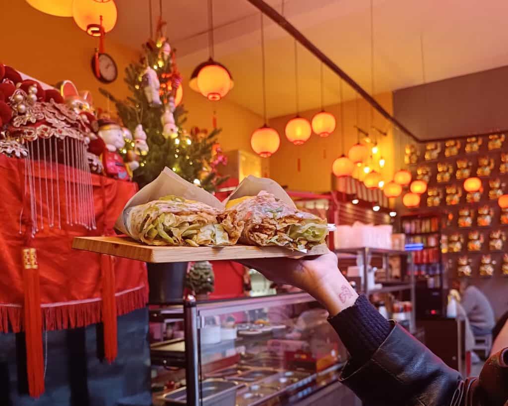 photo-of-hand-holding-delicious-crepe-in-beautiful-restaurant-during-food-tour-in-rotterdam-scaled