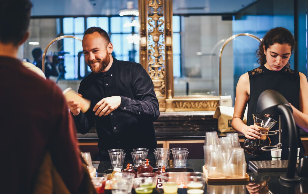 Man-practices-his-Dutch-while-ordering-drink-from-bar-bartender-smiles