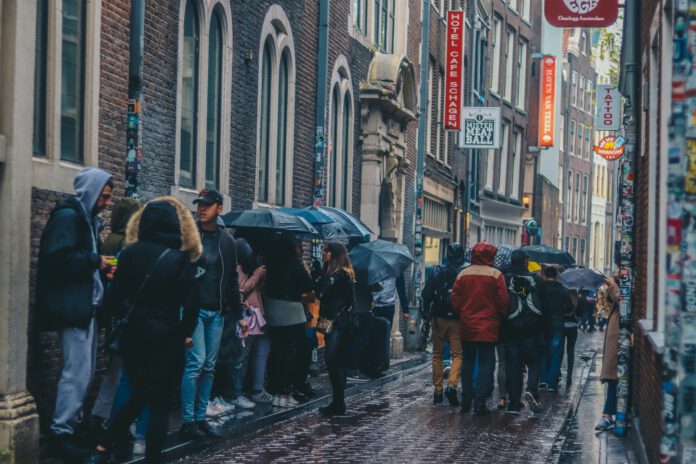 photo-of-crowd-sheltering-under-umbrellas-in-rainy-amsterdam