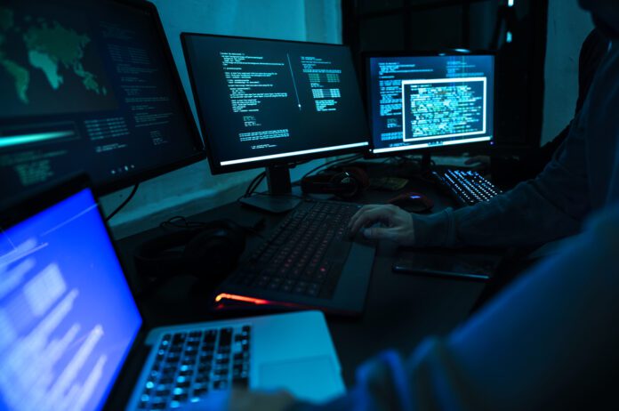 photo-of-cyber-criminal-hacking-on-multiple-computers-and-laptops