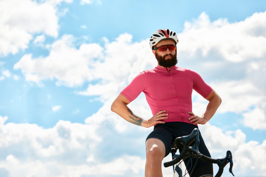 photo-of-man-with-hands-on-hips-on-top-of-bike-with-sky-in-background