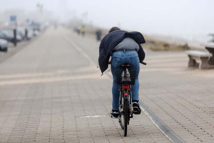 man-cycling-against-strong-wind