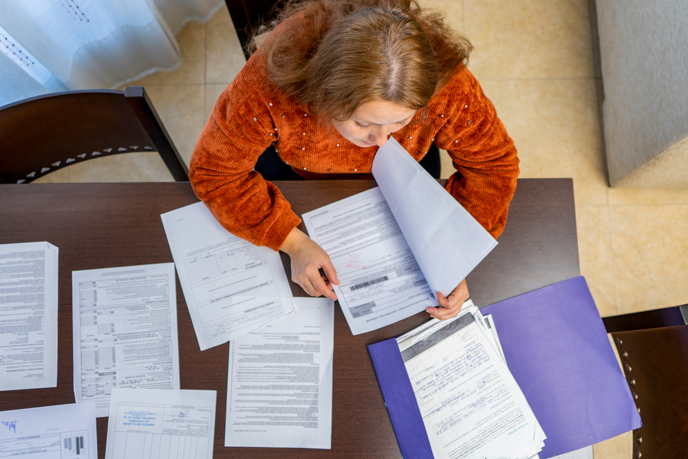 woman-looking-through-bills-paying-debt-netherlands