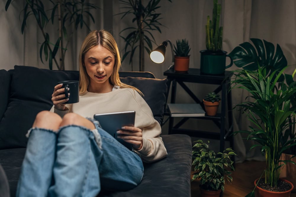 photo-of-young-woman-sitting-on-couch-in-her-apartment-in-the-Netherlands-where-she-has-taken-out-home-contents-insurance
