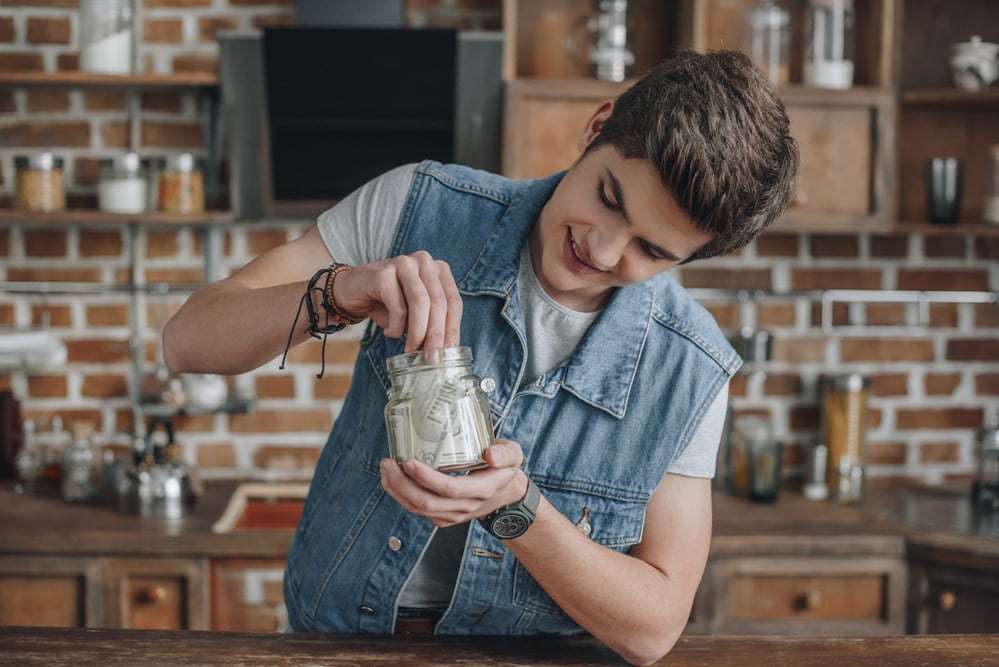 photo-dutch-teenager-putting-money-in-jar