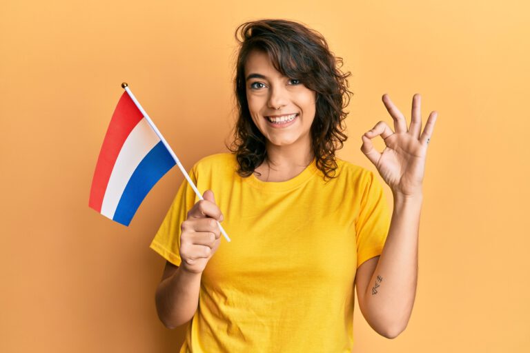 smiling-dutch-girl-holding-flag-and-making-ok-symbol