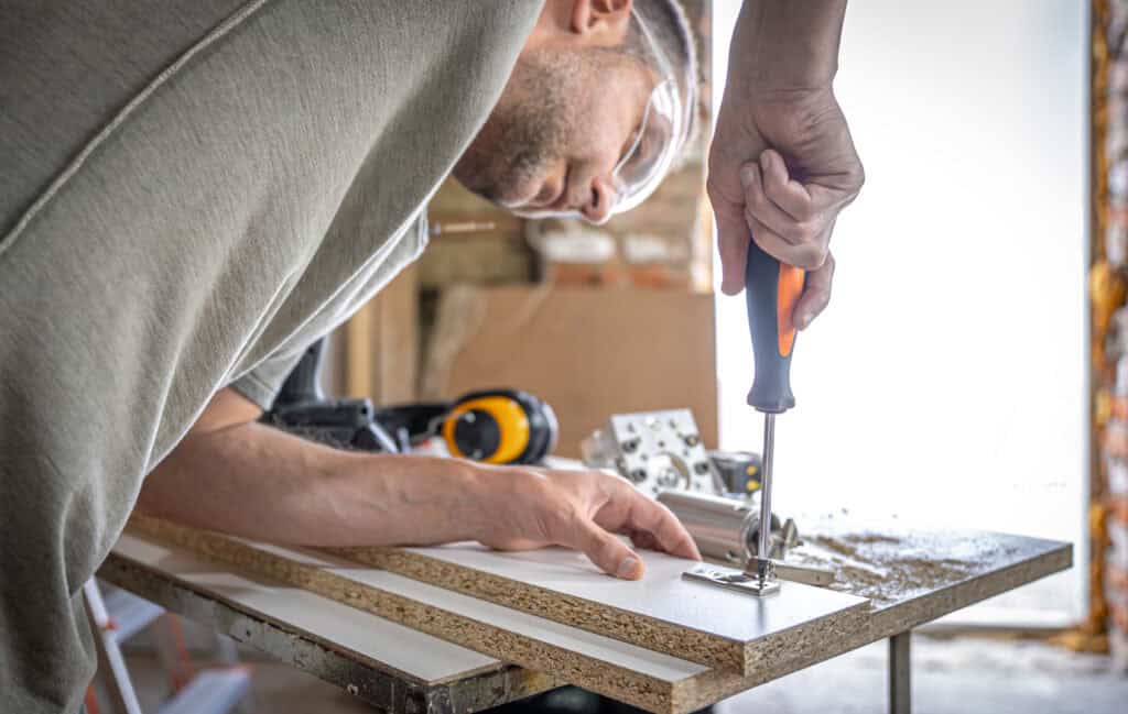 dutch-handyman-assembling-furniture-with-a-screwdriver-nails-and-hinges