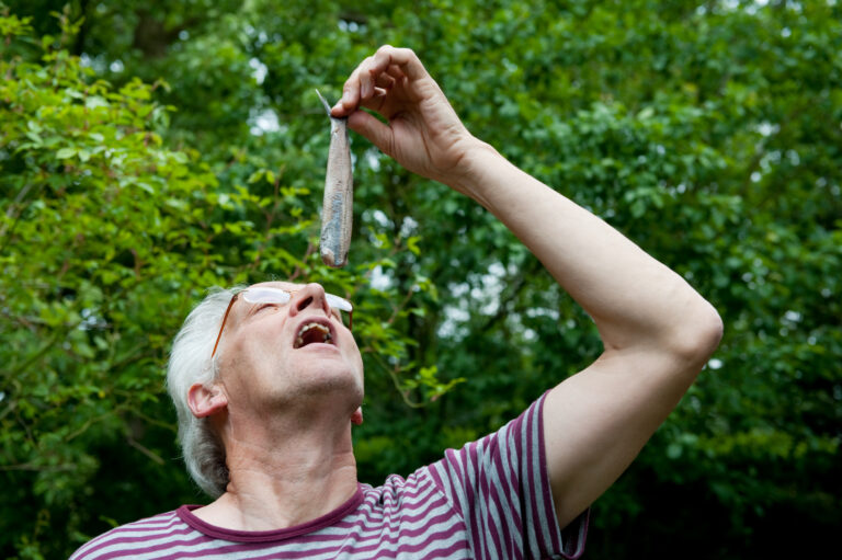 photo-of-dutch-man-eating-herring-holding-it-by-the-tail