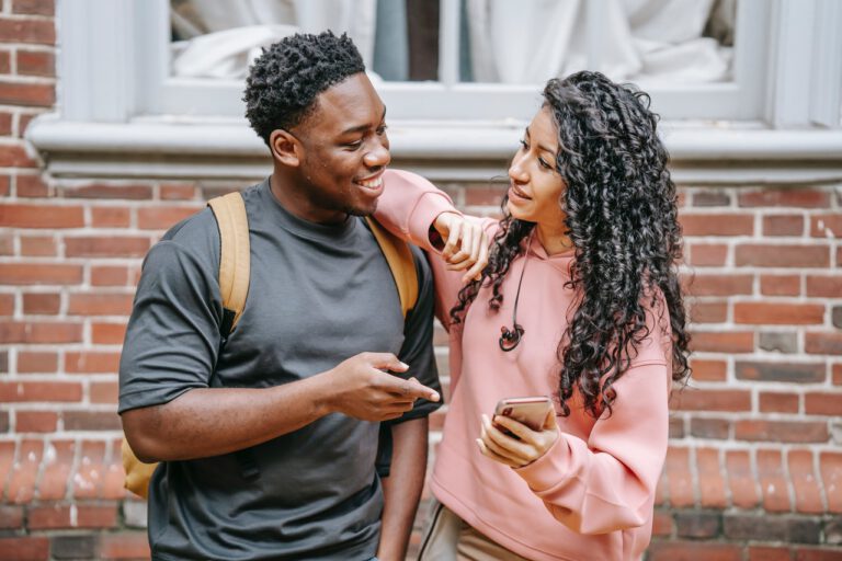 two-young-people-standing-outside-dutch-house-looking-at-phone