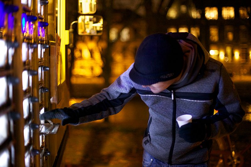 man-grabbing-food-from-snack-bar-vending-machine-netherlands