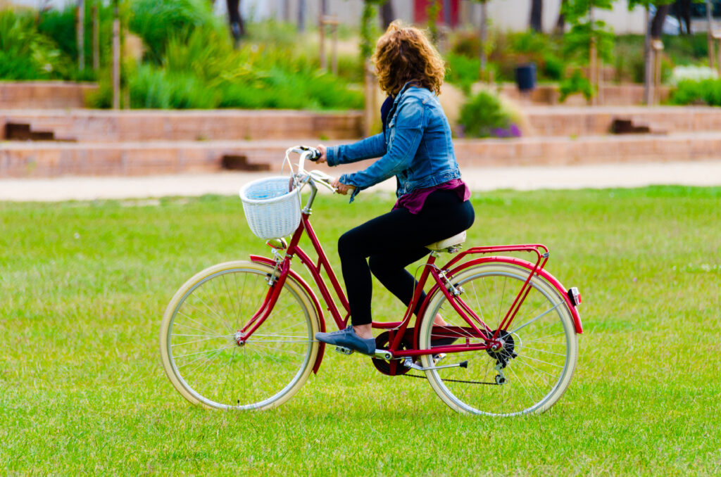 woman-riding-a-rented-bike-over-a-grassy-lawn-in-park-Amsterdam