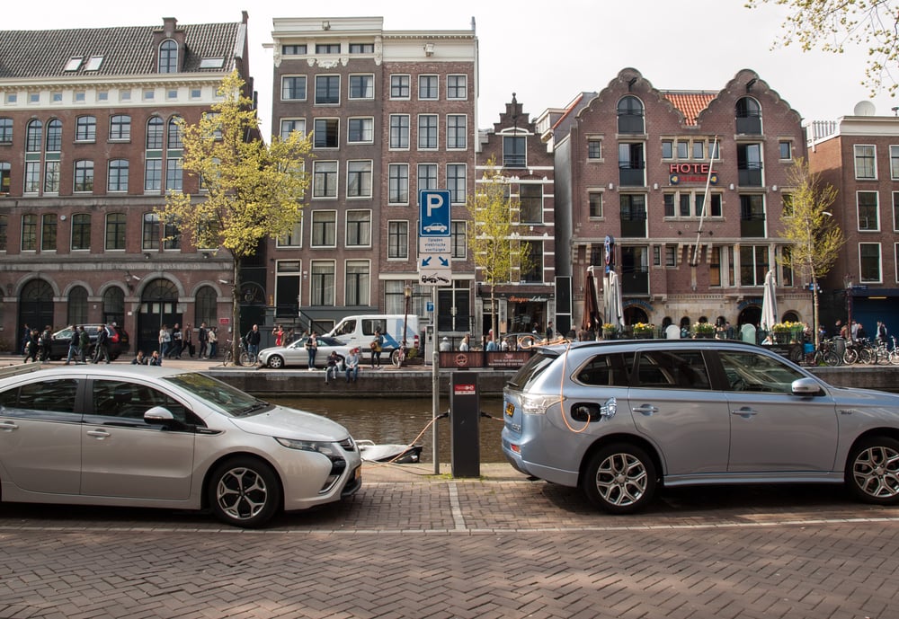 two-electric-cars-charging-by-amsterdam-canal