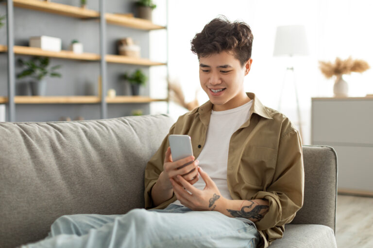 man-sitting-on-couch-using-EXPATHY-app-on-smartphone-to-talk-to-psychologist