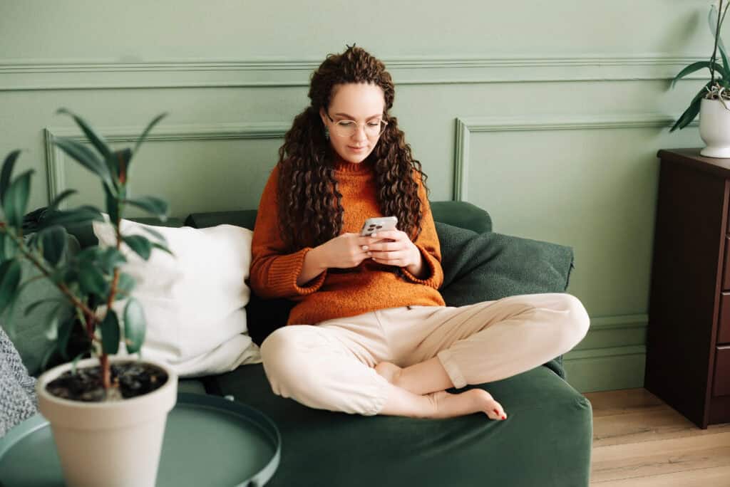 photo-of-expat-woman-relaxing-sofa-using-cell-phone-to-open-ing-bank-account-without-bsn