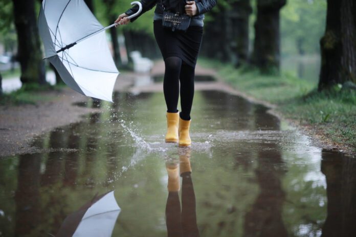 photo-of-person-walking-through-rain-puddle-with-umbrella