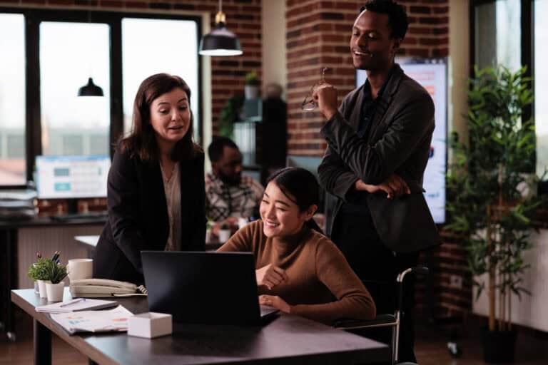 photo-of-colleagues-in-netherlands-discussing-work-at-table-over-laptop