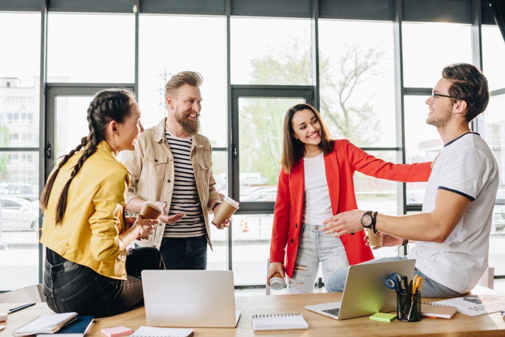 photo-of-four-happy-colleagues-talking-in-office