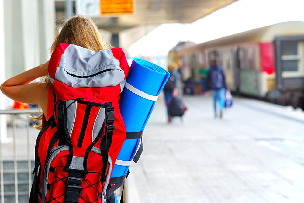 photo-of-young-woman-backpacking-train-station