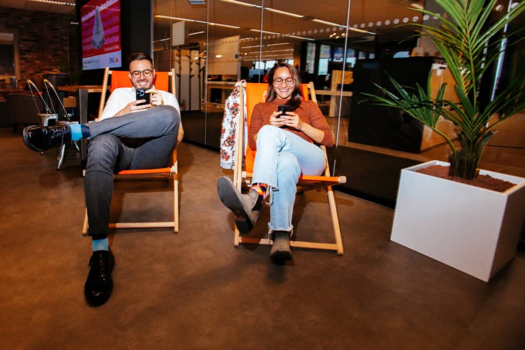 freelancers-na-holanda-percorrem-o-aplicativo-bancário-enquanto-reclinam-em-suas-cadeiras-e-fazem-uma-pausa