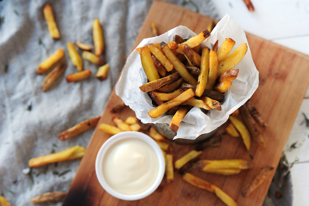 french-fries-with-mayonnaise-on-wooden-board-ready-to-be-eaten