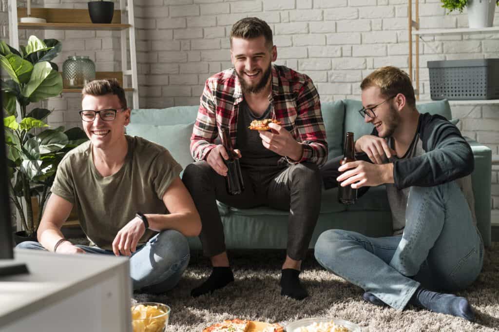 three-male-friends-in-the-netherlands-drinking-beer-eaiting-pizza-and-gaming