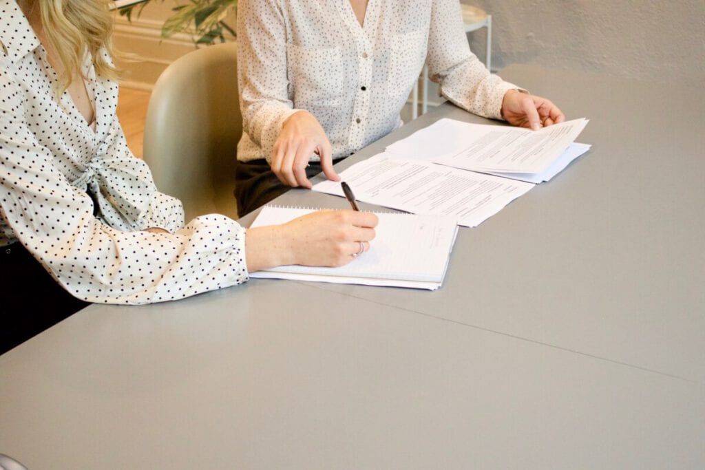 Photo-of-people-sitting-at-table-with-documents-registering-in-the-Netherlands-Registration