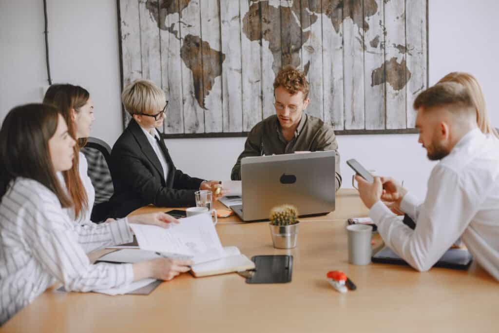 photo-of-employees-sitting-at-meeting-table-wearing-business-attire