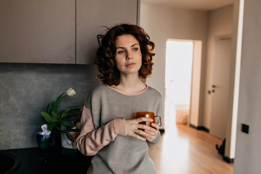 photo-of-woman-standing-at-home-drinking-tea-considering-getting-a-dismissal-lawyer-in-the-Netherlands