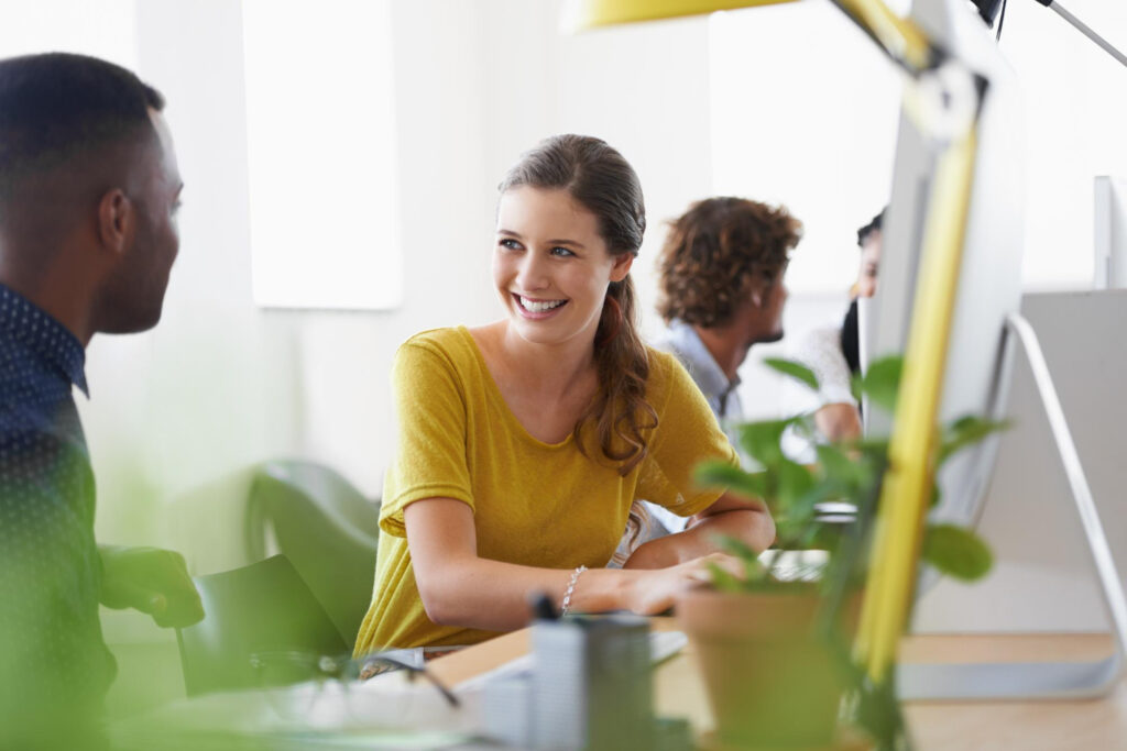 photo-of-woman-in-office-with-plants-turning-and-talking-to-someone