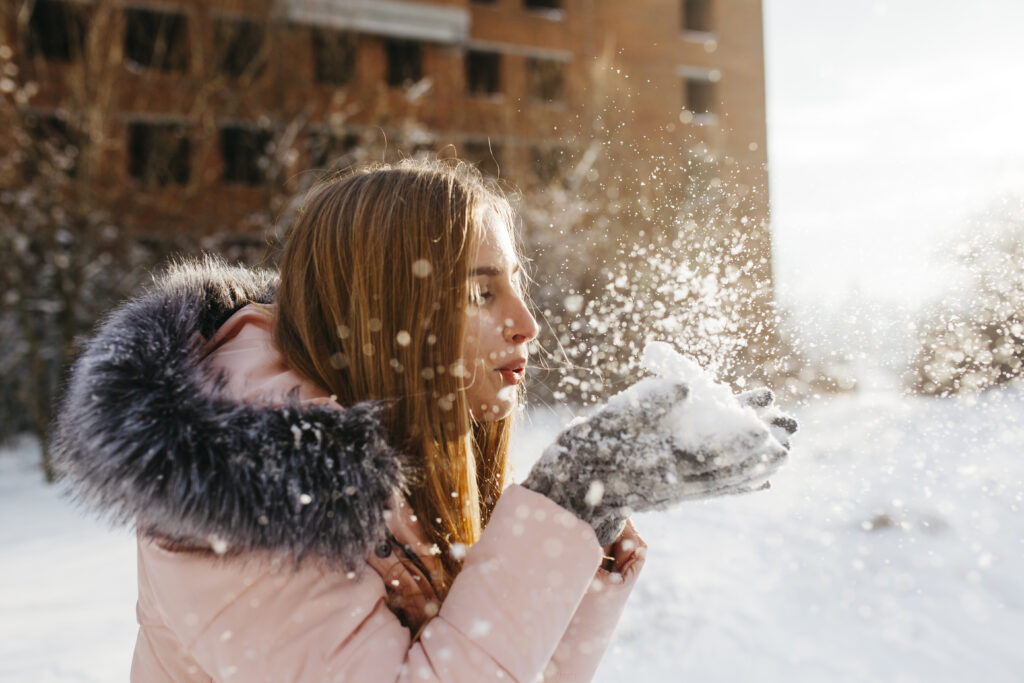 photo-of-girl-playing-in-the-snow-during-winter-in-the-netherlands-snowball-gray-gloves-pink-winter-jacket-straight-hair