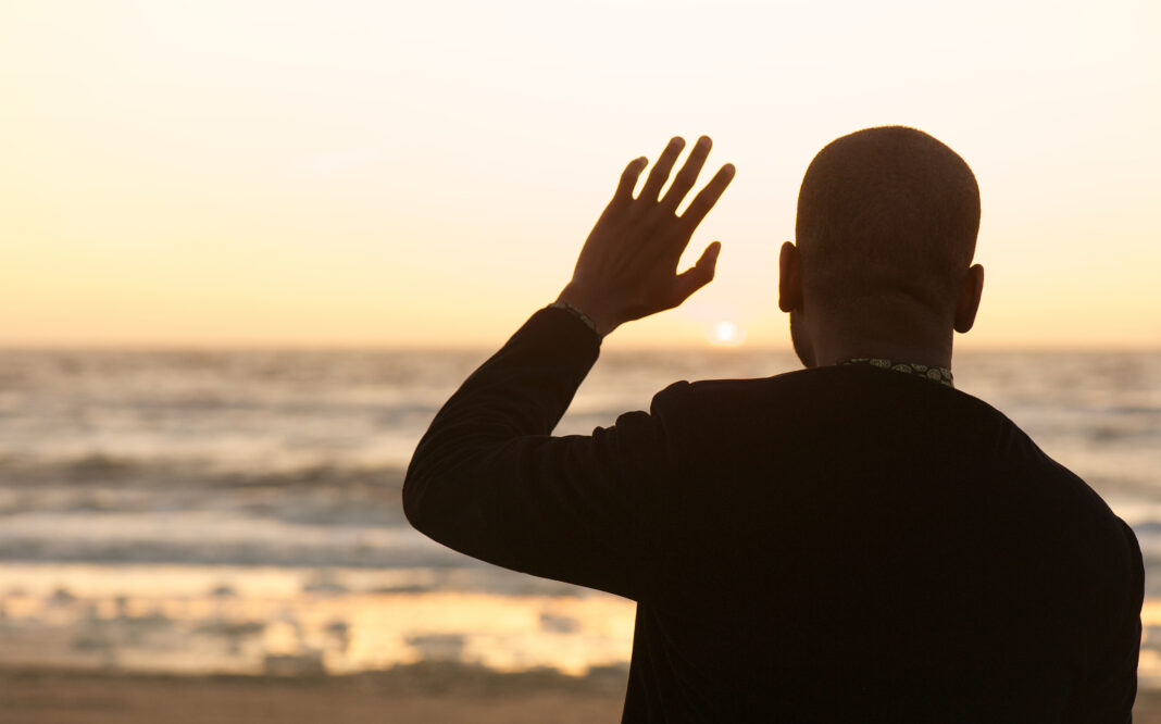 photo-of-man-waving-at-sunset