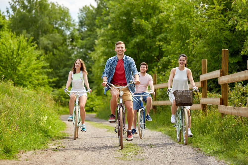 group-of-friends-cycling-together-in-the-summer