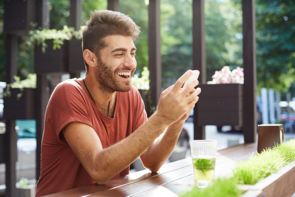 Happy-man-looking-at-his-savings-accounts-on-his-phone-using-neo-bank-bunq