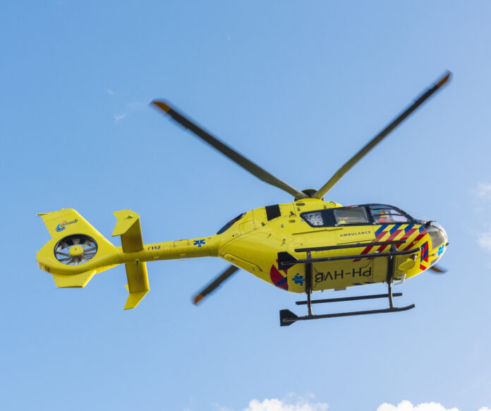 photo-of-yellow-helicopter-ambulance-in-netherlands-hovering-against-blue-skt