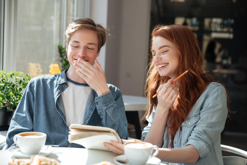 photo-of-boy-and-girl-sitting-in-cafe-laughing-at-Dutch-jokes