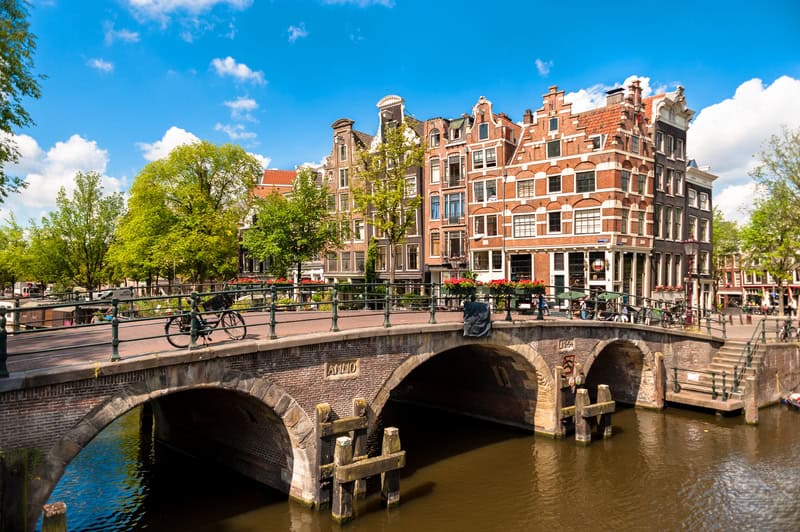 image-of-an-amsterdam-canal-with-buildings-in-the-background-and-a-bike-in-the-foreground-from-a-we-bike-tour