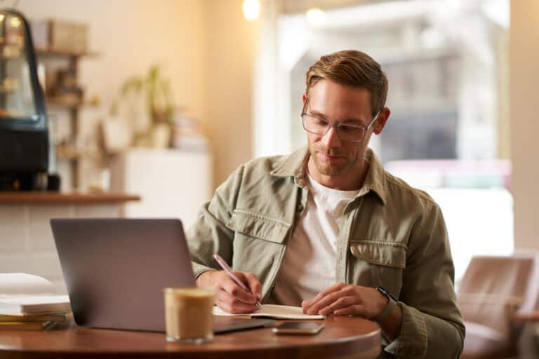 photo-of-freelancer-working-in-front-of-laptop-noting-important-things-to-know-before-becoming-freelancer-in-Netherlands