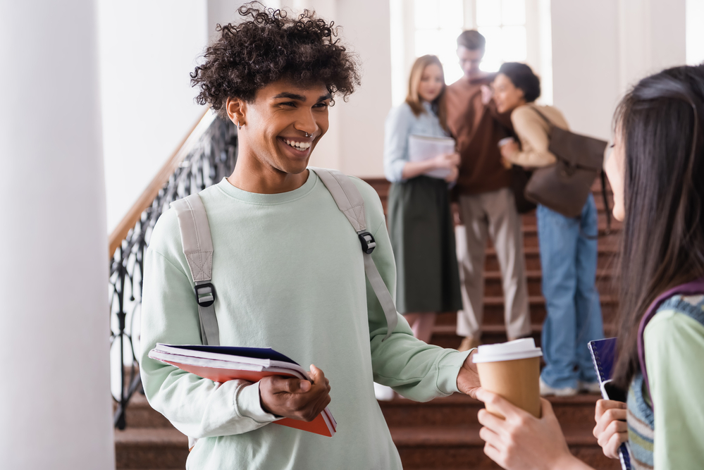 teenage-student-greets-friend-in-hallway-of-international-school-NAISR-the-netherlands
