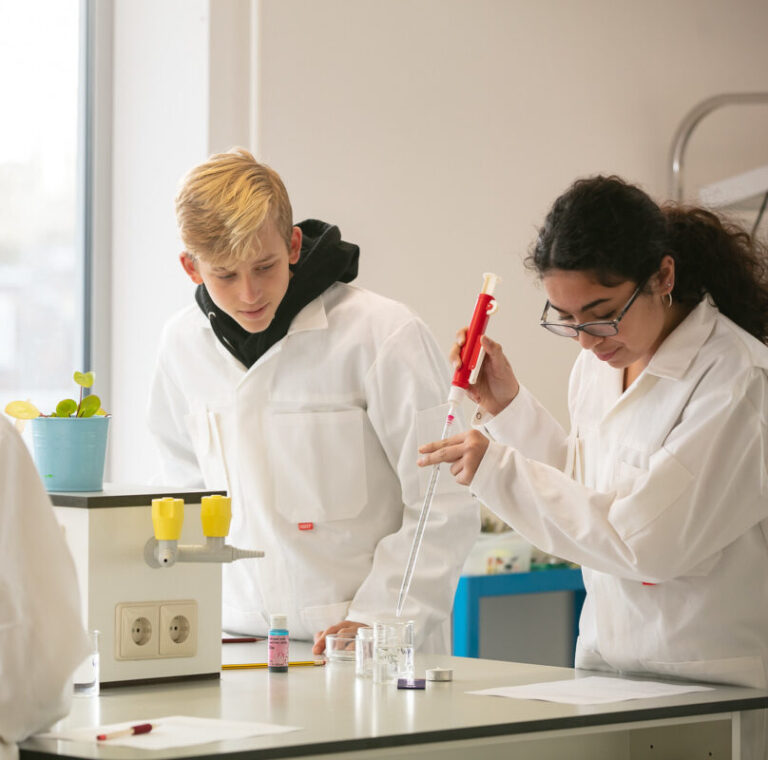 international-students-in-lab-coats-doing-experiment