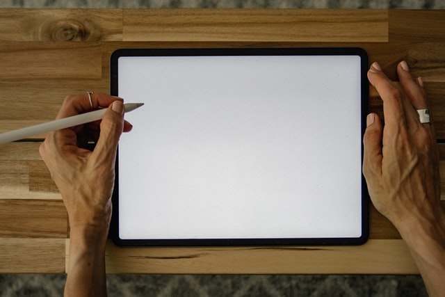Woman-holding-pencil-illustrating-on-an-iPad