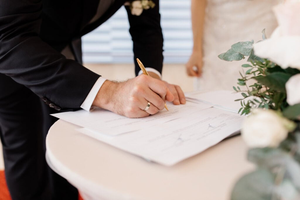photo-of-man-signing-document-at-wedding