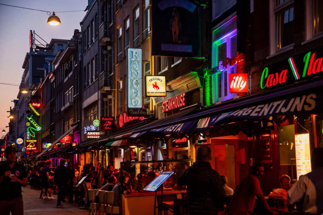 photo-of-side-street-on-leidseplein-in-amsterdam-cafes-restautants-bars-clubs-light-up-with-flashy-neon-signs-and-lights-lively-night-tourists-and-locals-having-food-and-drinks