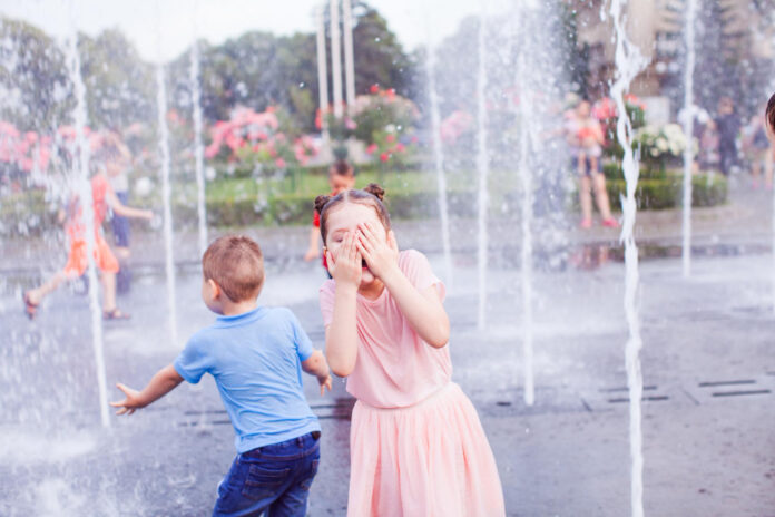 photo-of-young-girl-standing-in-sprinkler-during-dutch-heatwave