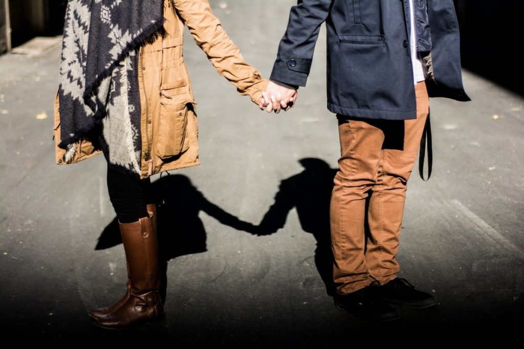 a couple holding hands on the street