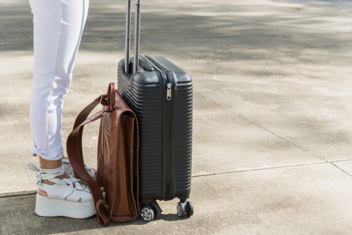 low-section-female-tourist-standing-road-with-luggage-leather-bag-scaled