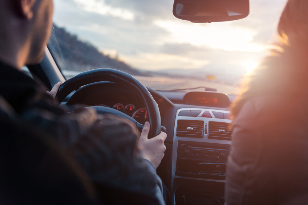 Woman-and-man-in-car-driving-into-the-light-of-dawn