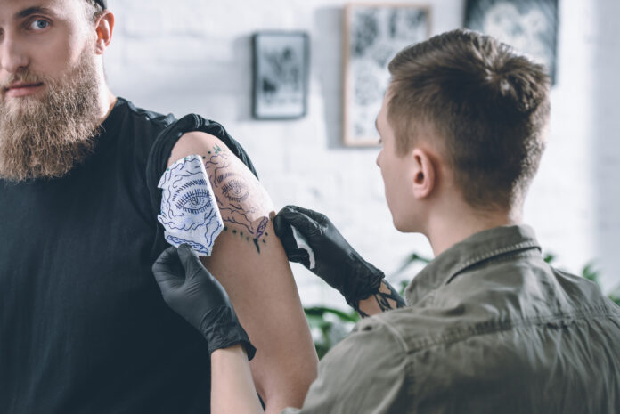 man-getting-a-tattoo-from-tattoo-artist