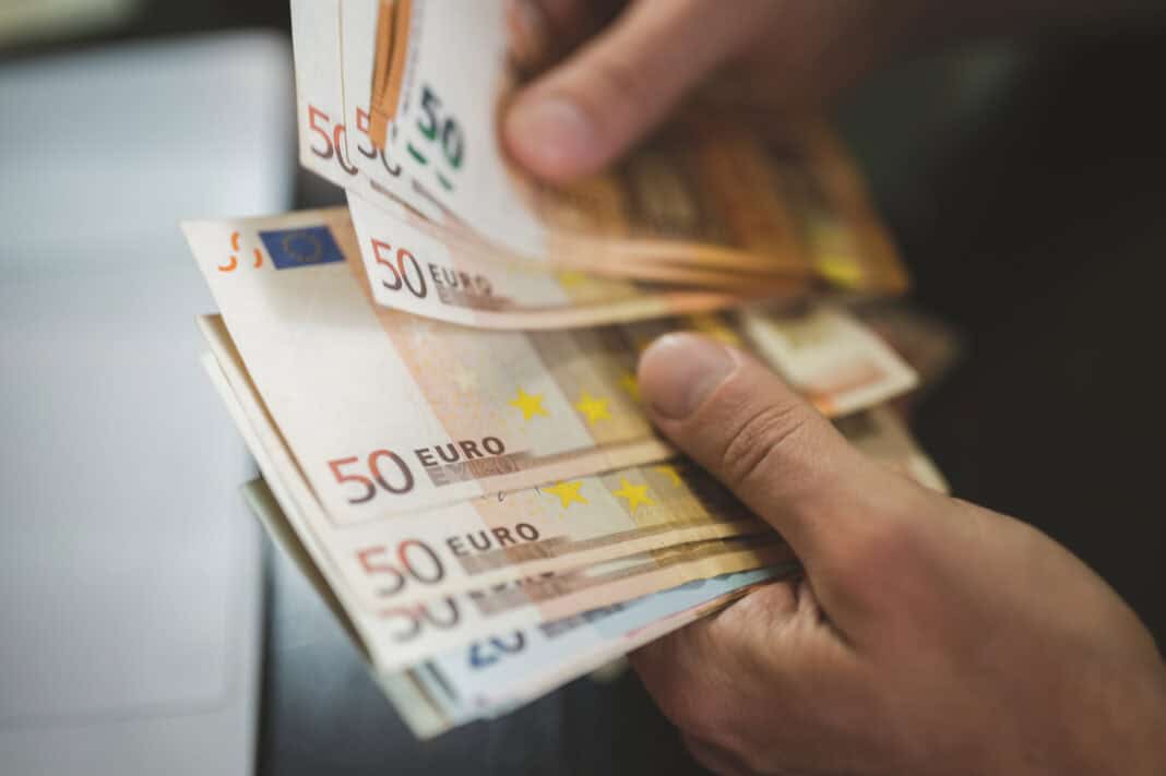 man-holding-a-stack-of-fifty-euro-notes