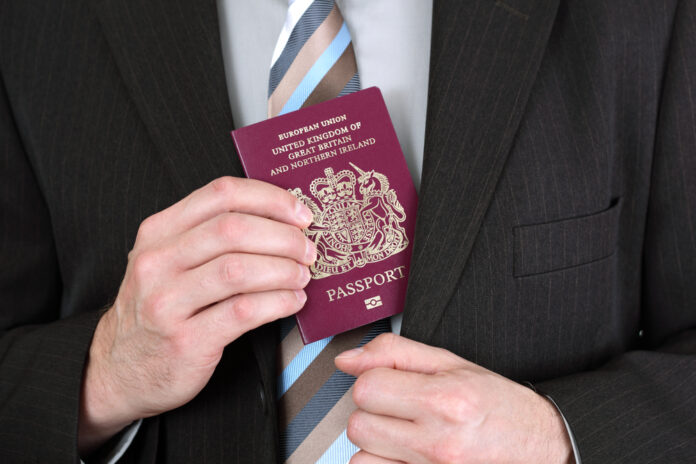 man-holding-british-passport-with-suit-and-tie