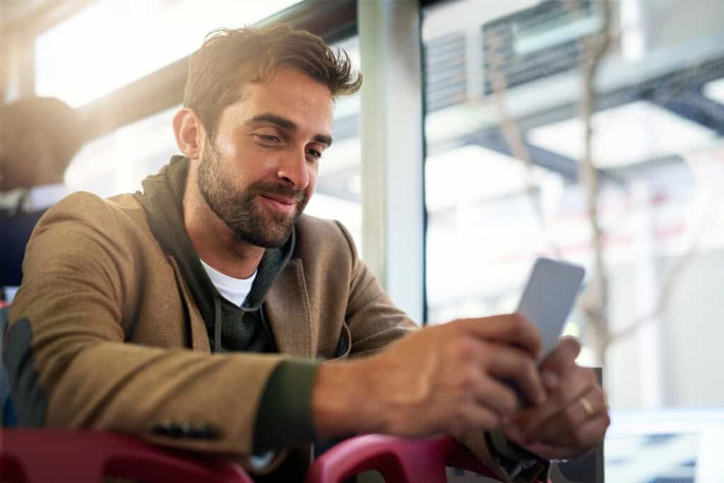 man-on-commute-in-bus-in-the-netherlands-using-lebara-fast-phone-network-to-scroll-social-media-scaled